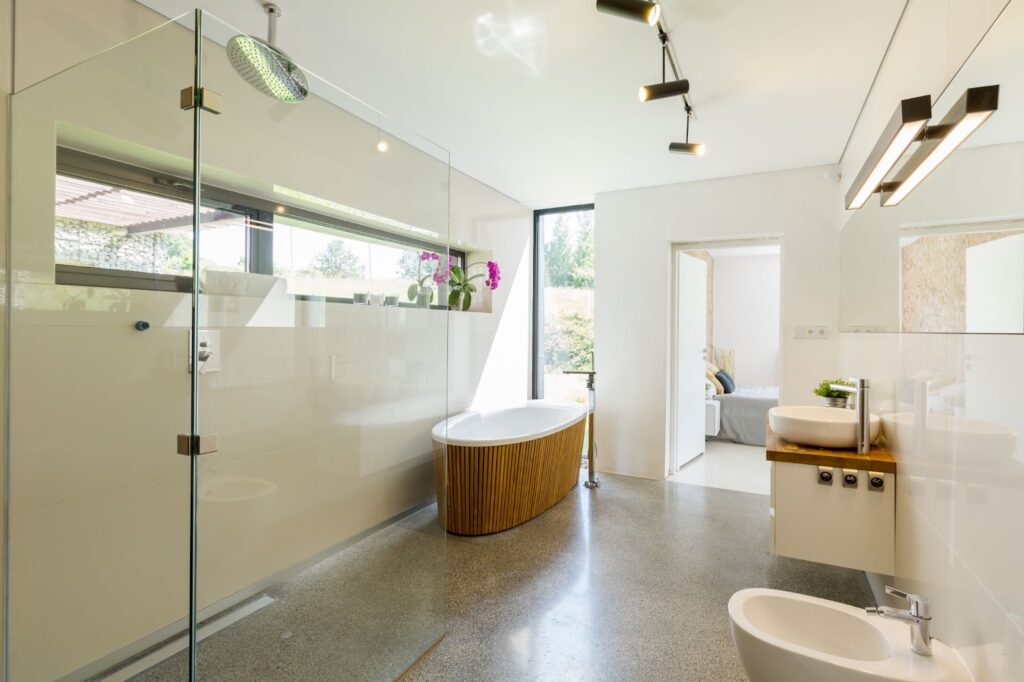 A spacious bathroom with eco-friendly fixtures, including a tub paneled with bamboo wood.