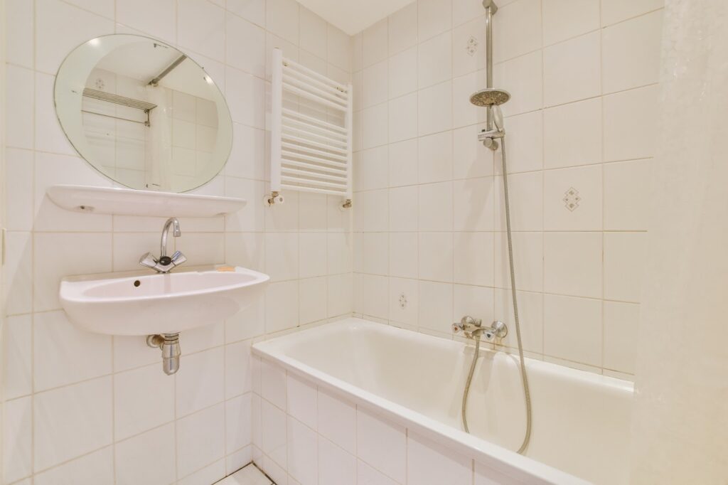 A shower and bathtub in a bathroom with white tiling.