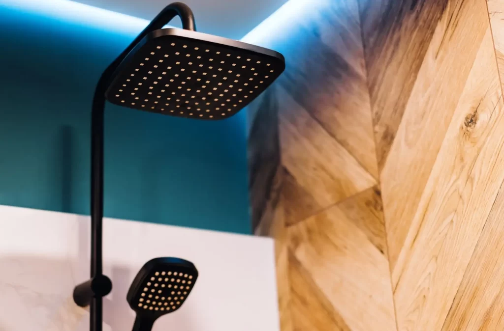 Shower head with a wooden wall on the side.