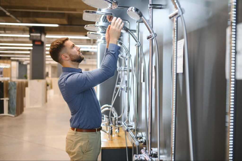 A man is carefully choosing the best shower for his bathroom.