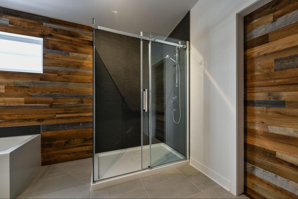 A modern bathroom featuring a European-style shower with barn wood accents.